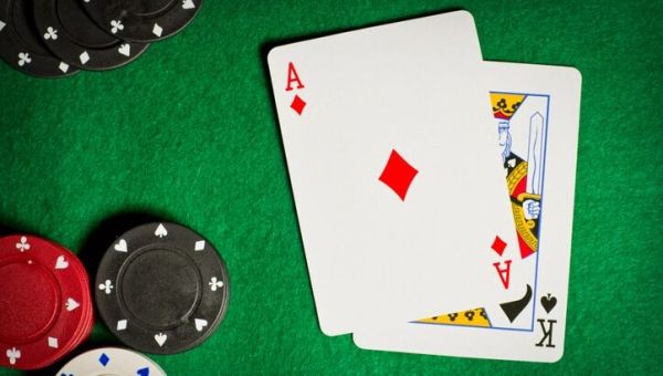 Poker table with gambling chips and two cards